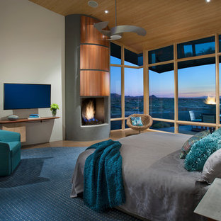 Großes Modernes Hauptschlafzimmer mit weißer Wandfarbe, Betonboden, Kamin, Kaminumrandung aus Beton und beigem Boden in Phoenix