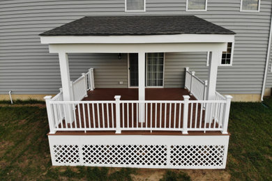 Modelo de terraza planta baja rural de tamaño medio en patio trasero y anexo de casas con zócalos y barandilla de varios materiales