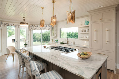 Large transitional single-wall light wood floor and beige floor open concept kitchen photo in Other with an undermount sink, glass-front cabinets, beige cabinets, quartzite countertops, white backsplash, stone slab backsplash, paneled appliances, an island and multicolored countertops