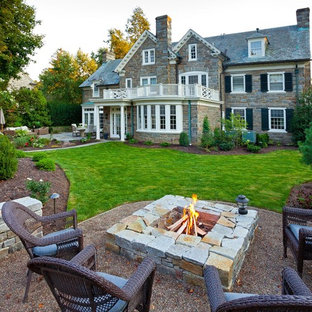 Неиссякаемый источник вдохновения для домашнего уюта: дворик в классическом стиле с местом для костра и покрытием из гравия без защиты от солнца