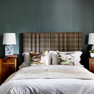 Cette image montre une chambre parentale bohème avec un mur bleu, une cheminée standard, un manteau de cheminée en bois, un sol marron et un sol en bois foncé.