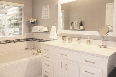 This is an example of a mid-sized traditional master bathroom in Atlanta with beaded inset cabinets, white cabinets, a drop-in tub, a corner shower, a two-piece toilet, white tile, grey walls, marble floors, marble benchtops, white floor, a hinged shower door, subway tile, an undermount sink and white benchtops.