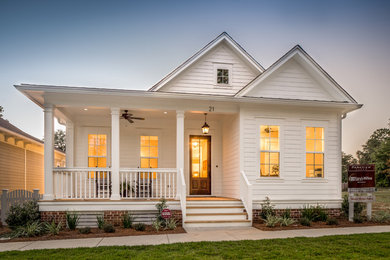 Inspiration for a mid-sized country white two-story wood gable roof remodel in Miami