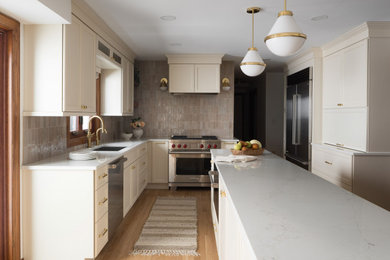 Transitional l-shaped medium tone wood floor eat-in kitchen photo in Milwaukee with recessed-panel cabinets, quartzite countertops, beige backsplash, terra-cotta backsplash, stainless steel appliances, an island and white countertops