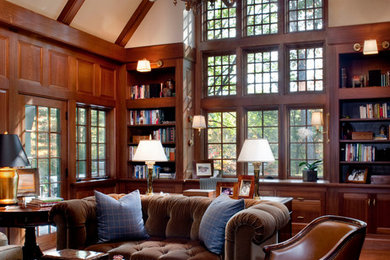Elegant freestanding desk medium tone wood floor study room photo in Boston with brown walls