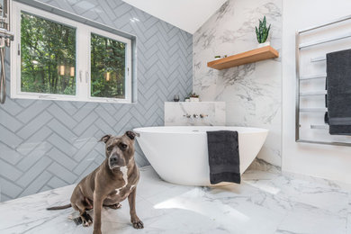 Example of a mid-sized trendy blue tile and glass tile porcelain tile, white floor, double-sink and vaulted ceiling bathroom design in Portland with shaker cabinets, light wood cabinets, a bidet, white walls, an undermount sink, quartz countertops, white countertops, a niche and a built-in vanity