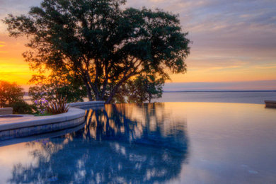 Hot tub - large contemporary backyard stamped concrete and custom-shaped infinity hot tub idea in Miami