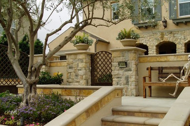 This is an example of a mediterranean two-storey beige house exterior in San Diego with stone veneer.