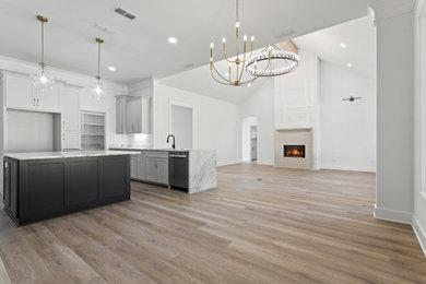 Living room - mid-sized country open concept laminate floor, beige floor and vaulted ceiling living room idea in Dallas with white walls, a standard fireplace, a concrete fireplace and a wall-mounted tv