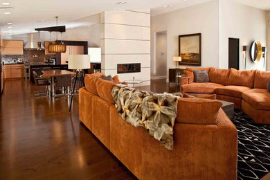 Example of a huge trendy medium tone wood floor and brown floor family room design in Las Vegas with beige walls, a two-sided fireplace and a tile fireplace