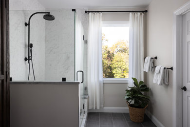 ワシントンD.C.にある高級な中くらいなトランジショナルスタイルのおしゃれなマスターバスルーム (コーナー設置型シャワー、分離型トイレ、白いタイル、ベージュの壁、グレーの床、開き戸のシャワー、シャワーベンチ) の写真