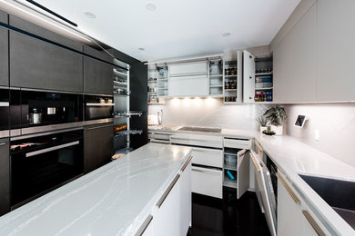 Inspiration for a mid-sized modern u-shaped kitchen remodel in Toronto with flat-panel cabinets, black cabinets, concrete countertops, stainless steel appliances, an island and white countertops