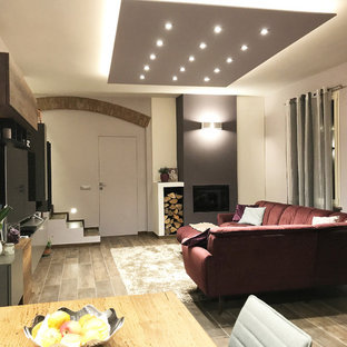 Idéer för att renovera ett stort funkis allrum med öppen planlösning, med ett finrum, rosa väggar, klinkergolv i porslin, en bred öppen spis, en spiselkrans i betong, en inbyggd mediavägg och flerfärgat golv