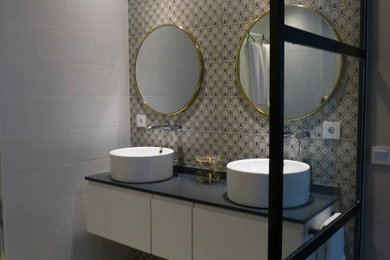 Modelo de cuarto de baño principal clásico renovado con puertas de armario blancas, lavabo sobreencimera y encimera de cuarzo compacto