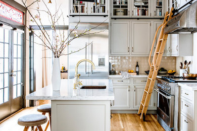 Example of a large transitional l-shaped light wood floor and brown floor open concept kitchen design in San Francisco with an undermount sink, gray cabinets, marble countertops, ceramic backsplash, stainless steel appliances, an island, shaker cabinets and beige backsplash