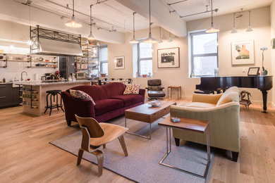 Urban open concept light wood floor living room photo in Other with beige walls