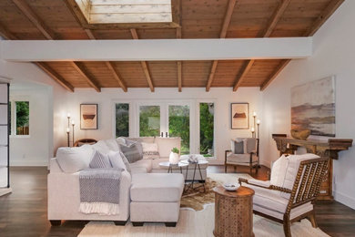 Large 1960s open concept laminate floor, brown floor and exposed beam living room photo in Orange County with white walls and no fireplace