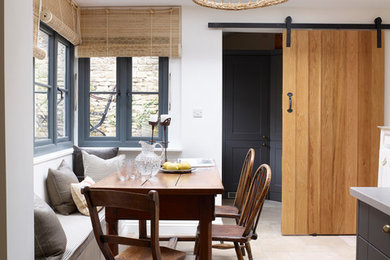 This is an example of a small country kitchen/dining combo in Oxfordshire with white walls.