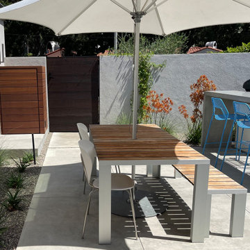 Smooth concrete patio with masonry and wood front wall