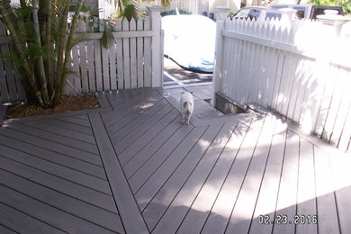 Photo of a large tropical backyard deck in Miami with no cover.