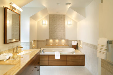 Contemporary bathroom in New York with an undermount sink, flat-panel cabinets, medium wood cabinets and a drop-in tub.