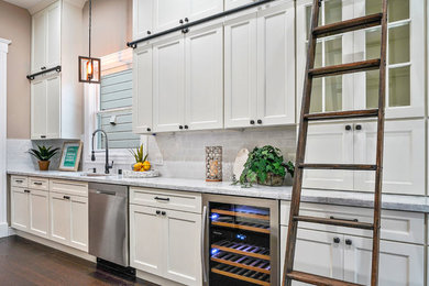 Mid-sized arts and crafts galley separate kitchen in San Francisco with an undermount sink, recessed-panel cabinets, white cabinets, granite benchtops, white splashback, subway tile splashback, stainless steel appliances, dark hardwood floors, no island, brown floor and grey benchtop.