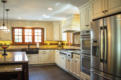 Large elegant l-shaped slate floor and brown floor eat-in kitchen photo in Other with a farmhouse sink, white cabinets, quartzite countertops, brown backsplash, an island, raised-panel cabinets, terra-cotta backsplash and stainless steel appliances