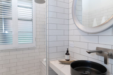 This is an example of a small contemporary 3/4 bathroom in Sydney with a curbless shower, white tile, porcelain tile, white walls, porcelain floors, a vessel sink, tile benchtops, white floor, white benchtops, a shower seat and a single vanity.