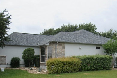 Inspiration for a timeless stone house exterior remodel with a hip roof and a shingle roof