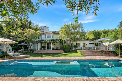 Photo of a large bohemian back swimming pool in Los Angeles with with pool landscaping and brick paving.