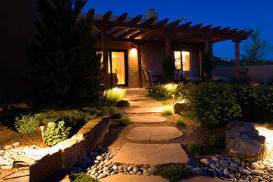 Photo of a mid-sized drought-tolerant front yard stone landscaping.