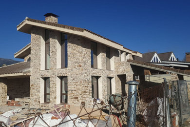 Modelo de fachada de casa rural de dos plantas con revestimiento de piedra