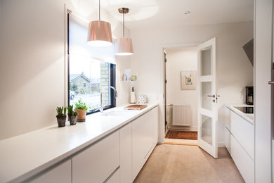 Photo of a scandinavian single-wall separate kitchen in Odense with flat-panel cabinets, white cabinets, linoleum floors, no island, beige floor, an undermount sink and stainless steel appliances.