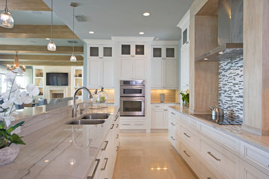 Photo of a beach style u-shaped eat-in kitchen in Orlando with recessed-panel cabinets, white cabinets, white splashback, matchstick tile splashback and panelled appliances.
