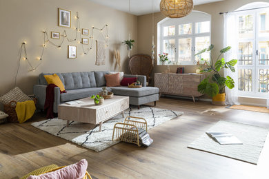 Mittelgroßes Nordisches Wohnzimmer mit gelber Wandfarbe und braunem Boden in Nürnberg