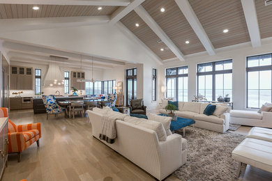 Design ideas for a beach style open concept living room in Miami with white walls and light hardwood floors.