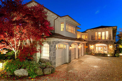 Photo of a large contemporary two-storey stucco white house exterior in New York with a hip roof and a metal roof.