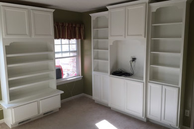 Home office library - mid-sized traditional built-in desk carpeted and beige floor home office library idea in Other with green walls