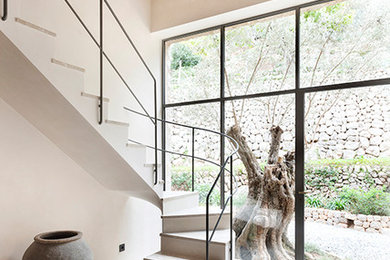 Photo of a mediterranean curved staircase in Other with metal railing.