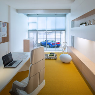 Design ideas for a large modern study in Vancouver with white walls, carpet, no fireplace, a built-in desk and yellow floors.