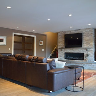 Exemple d'une salle de cinéma tendance de taille moyenne et ouverte avec un mur marron, un sol en linoléum et un téléviseur fixé au mur.