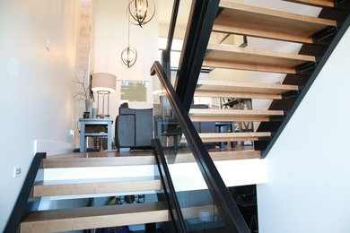 Large trendy wooden floating staircase photo in Other