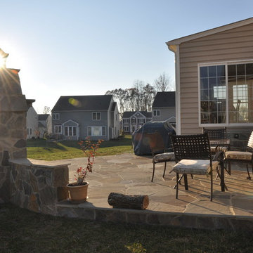 Stone patio with outdoor fireplace and steps in Manassas