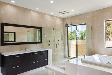 Large contemporary master bathroom in Miami with flat-panel cabinets, dark wood cabinets, a hot tub, a corner shower, beige tile, stone tile, beige walls, porcelain floors, an undermount sink and solid surface benchtops.