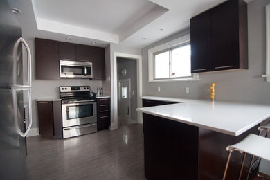 Inspiration for a mid-sized contemporary u-shaped porcelain tile and gray floor enclosed kitchen remodel in Other with an undermount sink, flat-panel cabinets, dark wood cabinets, solid surface countertops, stainless steel appliances and white countertops