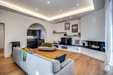 Example of a mid-sized trendy light wood floor living room design in Rome with a corner fireplace