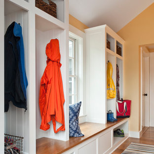 Idee per un ingresso con anticamera classico di medie dimensioni con pareti gialle e pavimento in legno massello medio