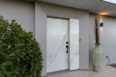 バンクーバーにある高級な中くらいなトランジショナルスタイルのおしゃれな玄関ドア (グレーの壁、トラバーチンの床、ベージュの床、パネル壁、白いドア) の写真