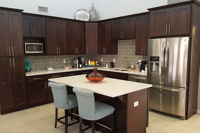 Mid-sized trendy l-shaped ceramic tile eat-in kitchen photo in Orlando with a single-bowl sink, recessed-panel cabinets, dark wood cabinets, granite countertops, brown backsplash, ceramic backsplash, stainless steel appliances and an island