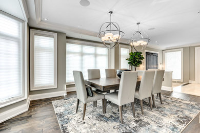 Inspiration for a transitional dark wood floor and brown floor enclosed dining room remodel in Toronto with gray walls